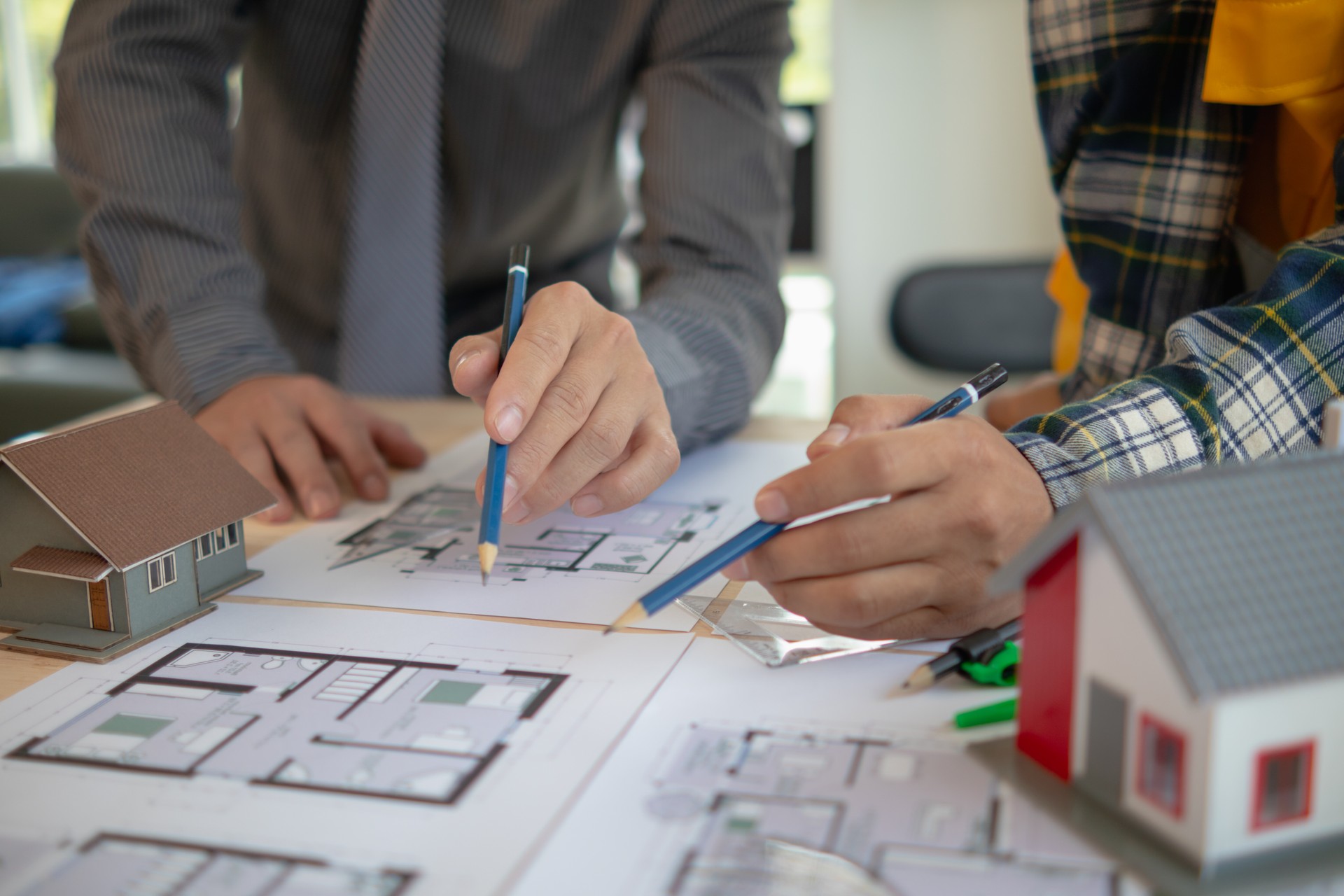 Construction engineers discuss and exchange ideas with architects to improve house plans to meet customer needs. A concept for exchange of design ideas between construction engineers and architects.